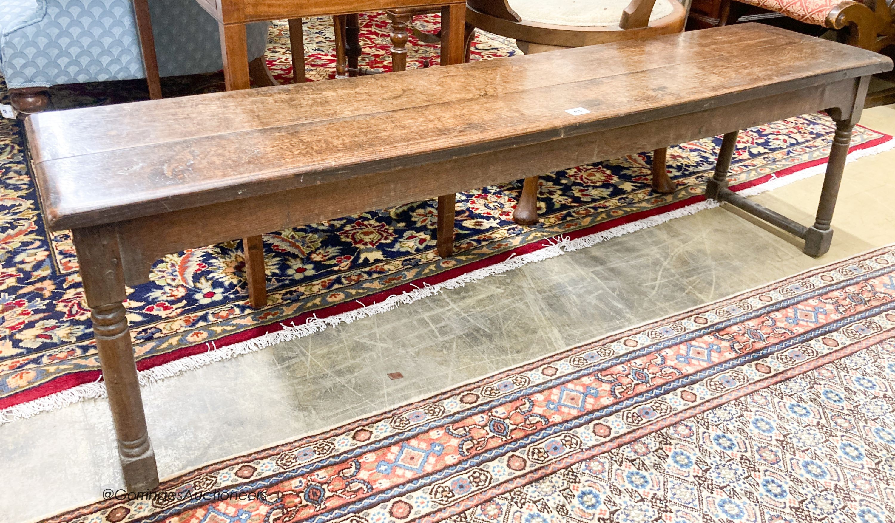 An 18th century style oak low bench seat, length 140cm, depth 32cm, height 42cm